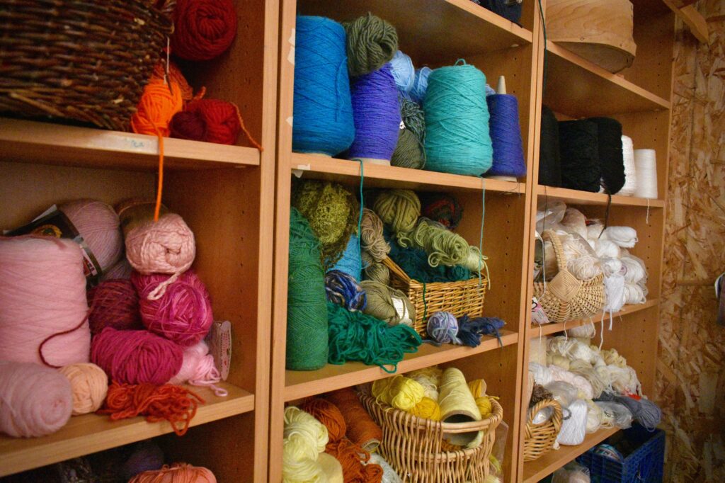 Colorful skeins of yarn displayed within wooden cubbies