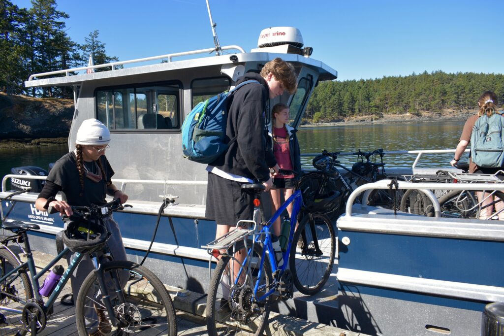 Campers load bicycles into a boat