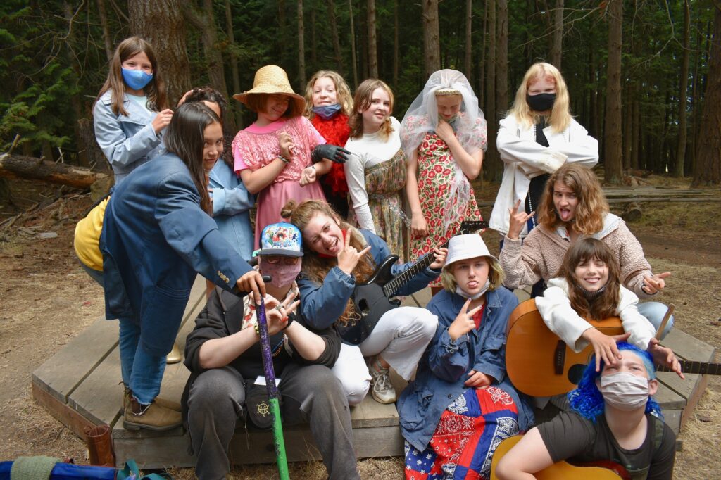 A group of campers and staff display silly poses while wearing costumes
